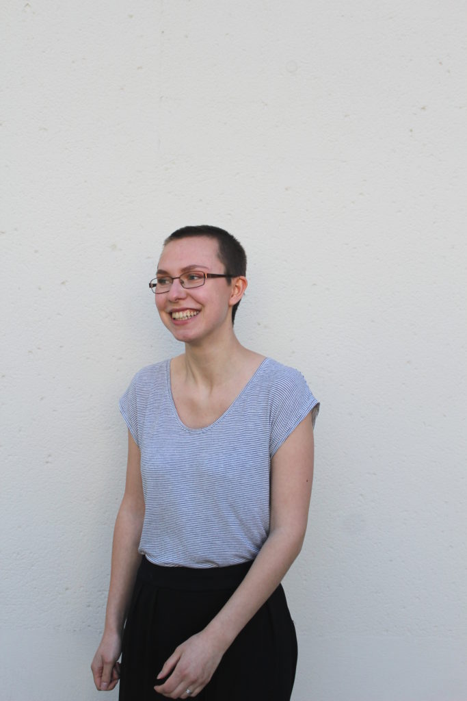 Porträtbild der Kolumnistin Annika Seiferlein. Sie lacht und draußen scheint es warm zu sein. 
