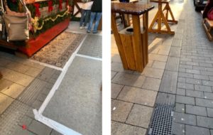 Die Leitstreifen sind durch Tische und Stände verstellt.
