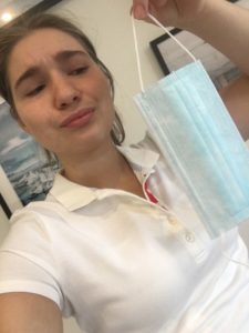 Redakteurin Sophie Berns hält eine Maske und schaut sie abwertend an