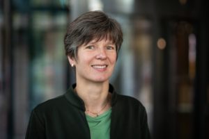 Katja Bühler lächelt. Sie trägt ein grünes Tshirt und darüber eine dunkle Thermojacke. Sie hat kurze, brünette Haare.