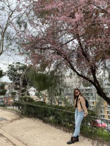 Kolumnistin Johanna Klima steht unter einem rosa blühenden Baum