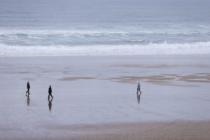 Maixabel läuft am Strand entlang. Mit etwas Abstand folgen ihr zwei Leibwächter. 