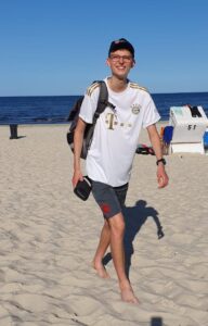 Der Autor des Textes in einem FC Bayern-Trikot am Strand. Hinter ihm die Ostsee.