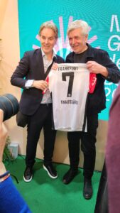 Karl Ove Knausgård und Jan Åge Fjørtoft. halten zusammen ein ein Eintracht Frankfurt-Trikot.